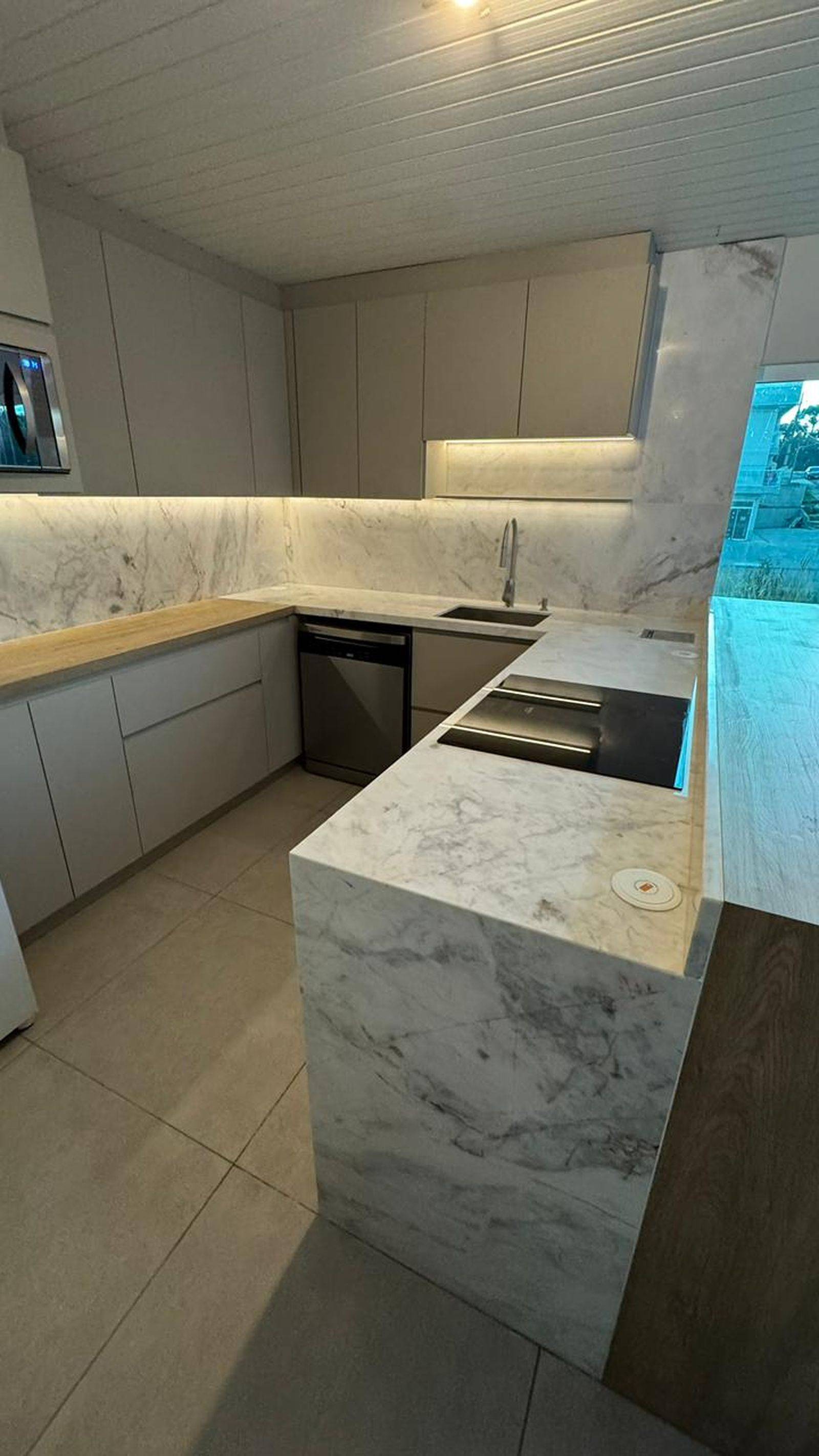 Detalhe de cozinha em mármore branco Paraná com cuba esculpida.